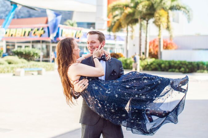 The groom carrying the bride following their Orlando elopement.